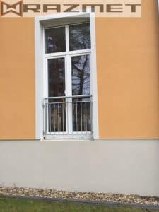 Weißes Fenster mit Gitter an orangefarbener Wand.