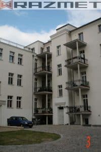 Wohngebäude mit Balkonen und gepflastertem Hof.