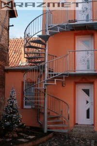 Außentreppe an einem orange-farbenen Wohnhaus.
