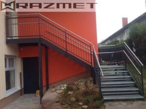 Metalltreppe an orangem Gebäude mit Geländer