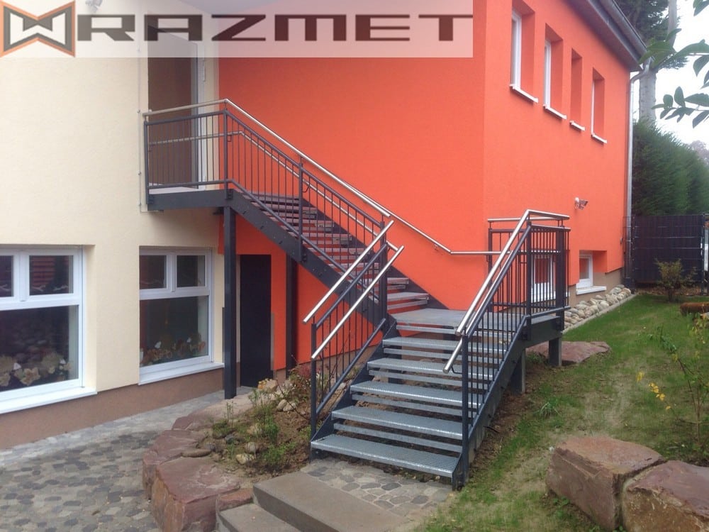Metall-Außentreppe an orangefarbenem Haus.