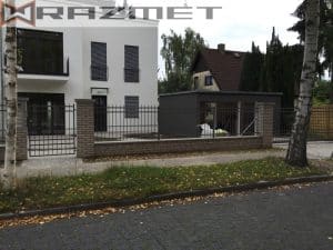 Moderne weiße Villa mit Zaun und Birken.