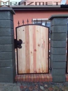 Holztür mit Metallverzierungen und Steinpfosten.