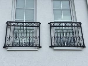 Zwei Fenster mit schmiedeeisernen Geländern.