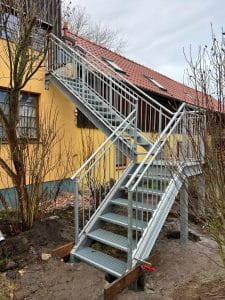 Metalltreppe am gelben Haus mit Geländer.